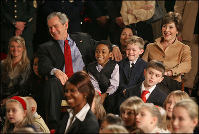 President George W. Bush and Mrs. Laura Bush sit with children of deployed U.S. military personnel and watch a performance of "Willy Wonka" by members of The Kennedy Center Education Department in the East Room Monday, Dec. 4, 2006. White House photo by Eric Draper 